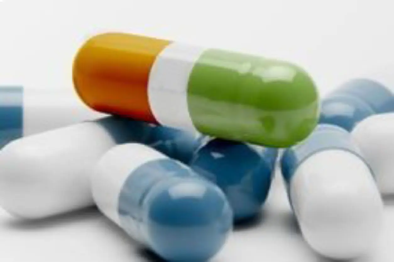 Close-up of colorful medical capsules on a white surface.