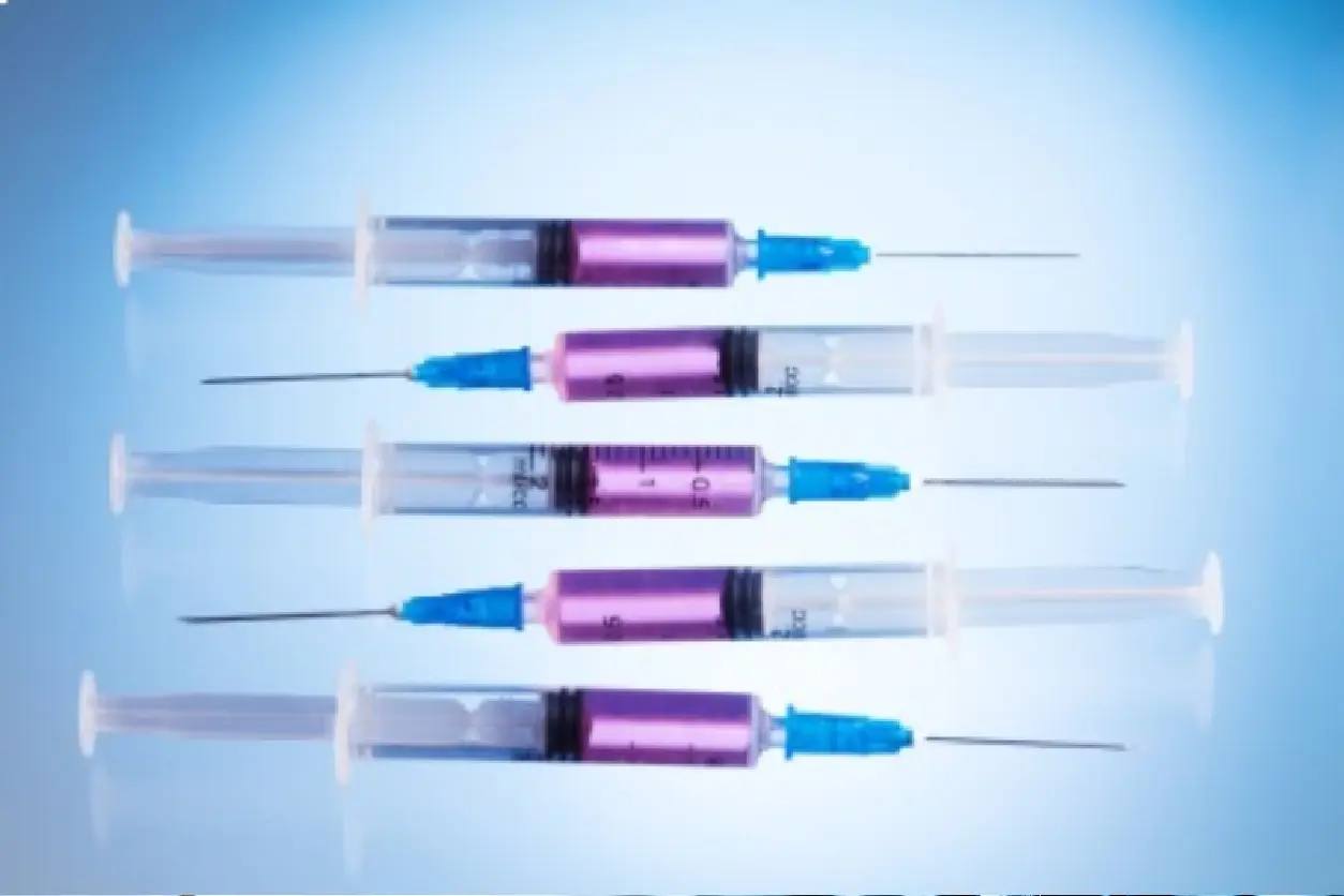 Five syringes with purple barrels and blue caps arranged horizontally.