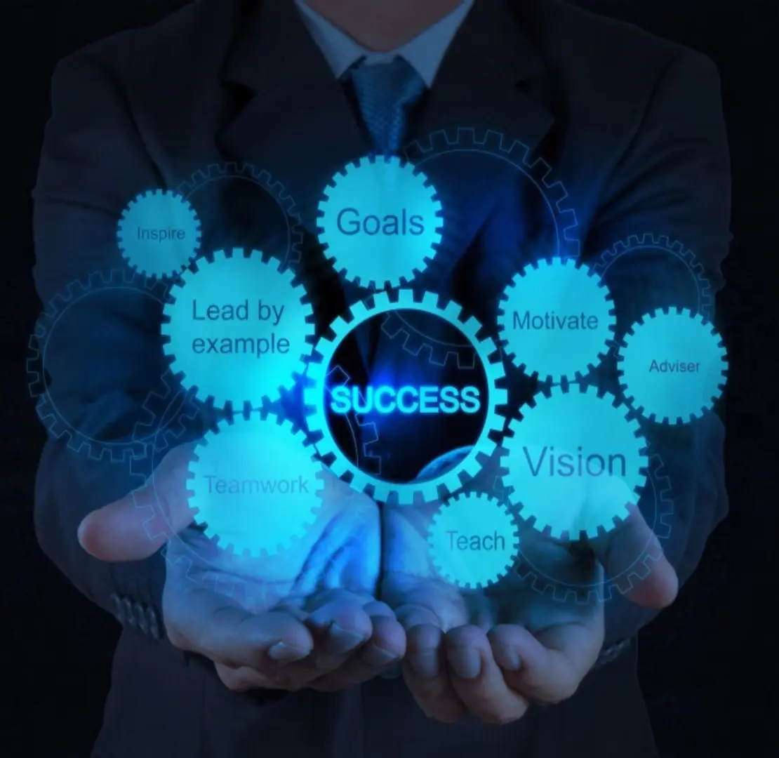 Glowing gears with success and related concepts in a businessman's hands.
