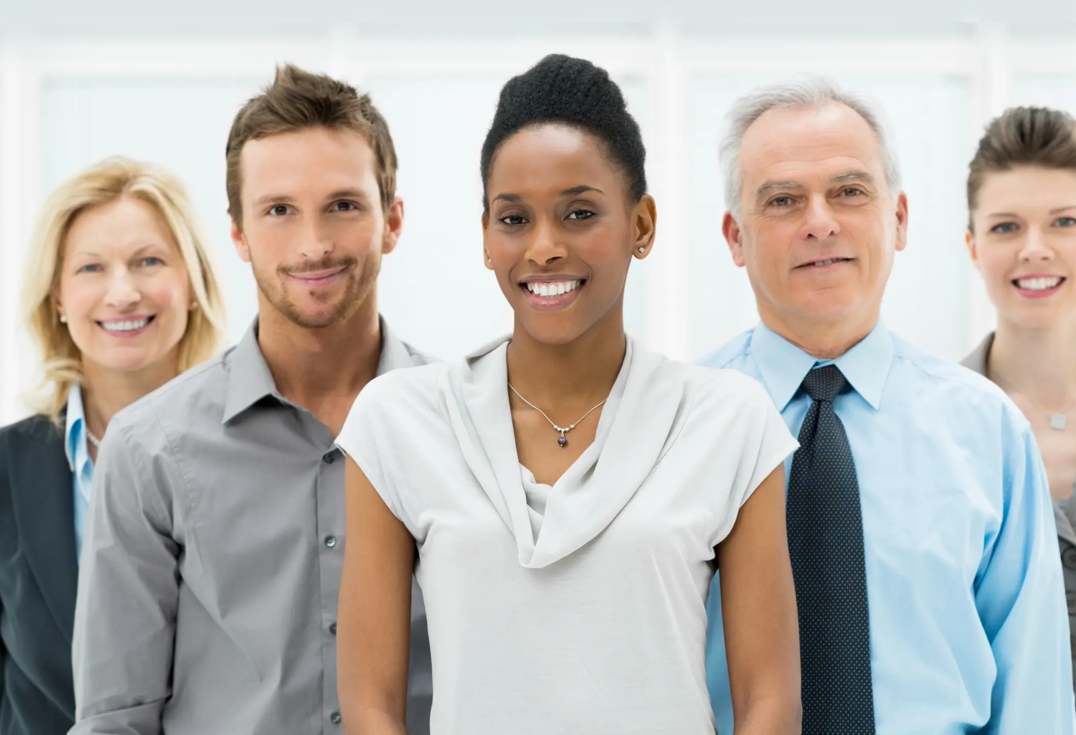 A diverse group of four smiling professionals standing together.