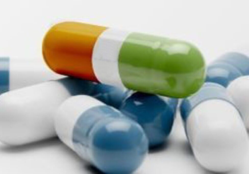 Close-up of colorful medical capsules on a white surface.