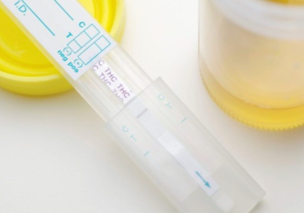 Close-up of a pregnancy test showing positive result on a white surface.