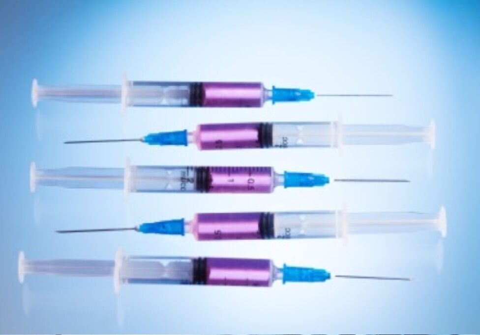 Five syringes with purple barrels and blue caps arranged horizontally.